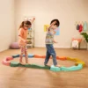 Dwoje dzieci ćwiczy równowagę na muzycznej ścieżce sensorycznej Balance & Groove Set SOFT COLORS B. toys w pokoju zabaw